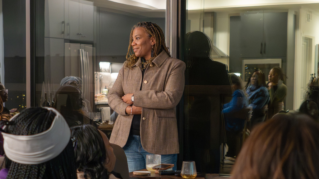 Chanda Smith Baker speaking with attendees during an intimate community gathering.